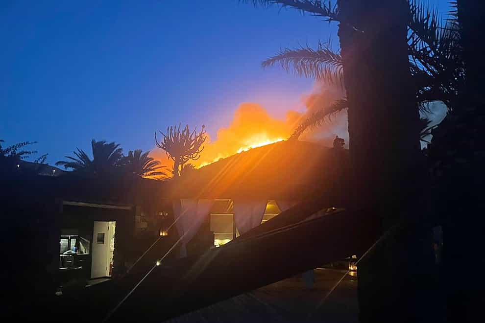 Flames burn beyond Giorgio Armani’s villa on the Sicilian island of Pantelleria (Armani Press Office Via AP)