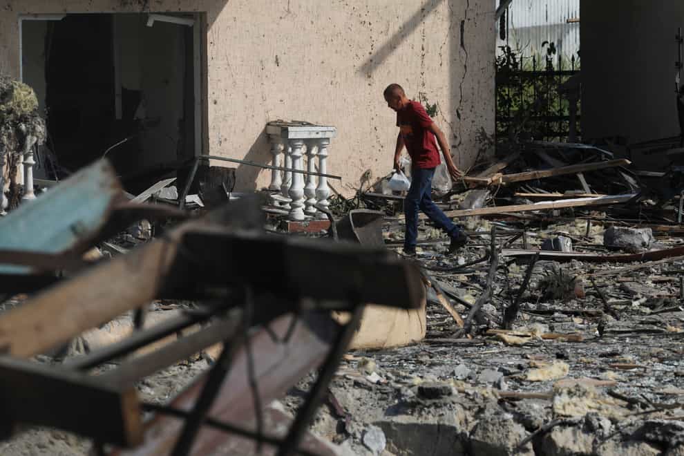 A man passes by buildings of local resort destroyed following recent Russian missile attacks in Odesa region, Ukraine, Thursday, Aug. 18, 2022. (AP Photo/Nina Lyashonok)
