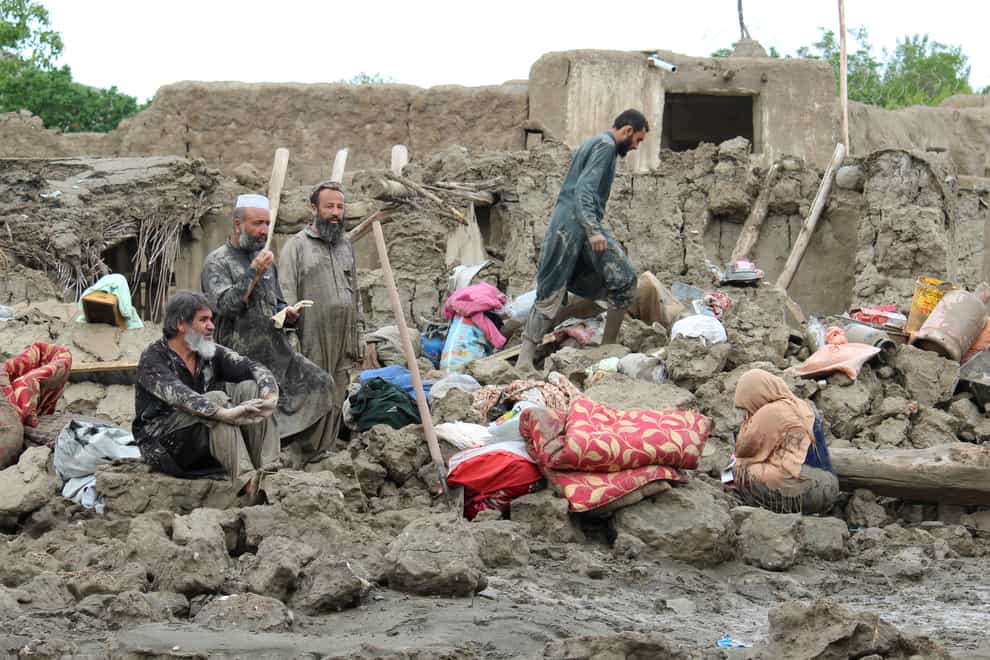People collect their belongings from their damaged homes after heavy flooding in the Khushi district of Logar province, Afghanistan (Shafiullah Zwak/AP)