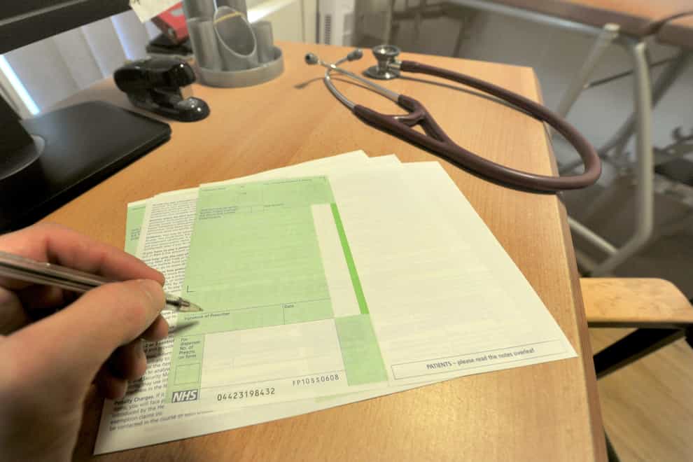 A GP writes a prescription in a practice room (Anthony Devlin/PA)