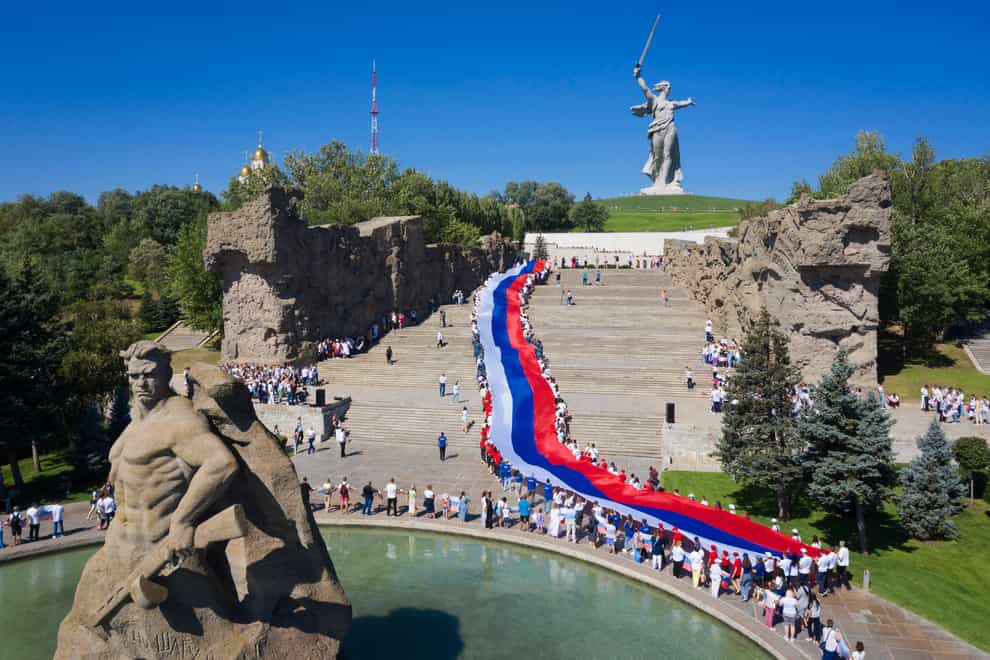 People carry a giant Russian flag during celebration of the Day of The National Flag in Mamayev Kurgan, the Second World War Battle of Stalingrad memorial, in Volgograd, Russia (Alexandr Kulikov/AP)
