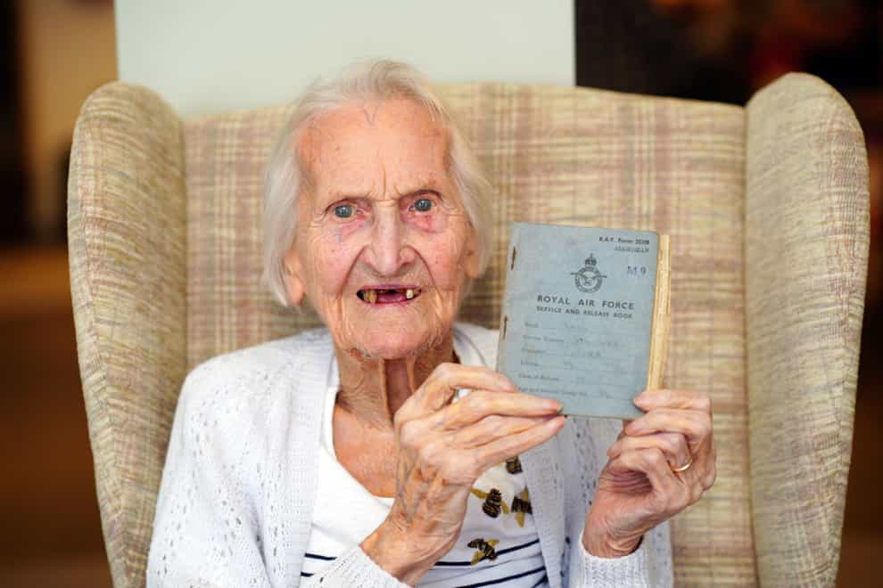 99-year-old WAAF veteran, Mrs Margaret ‘Peggy’ Terry, holds her RAF service record document (PA)