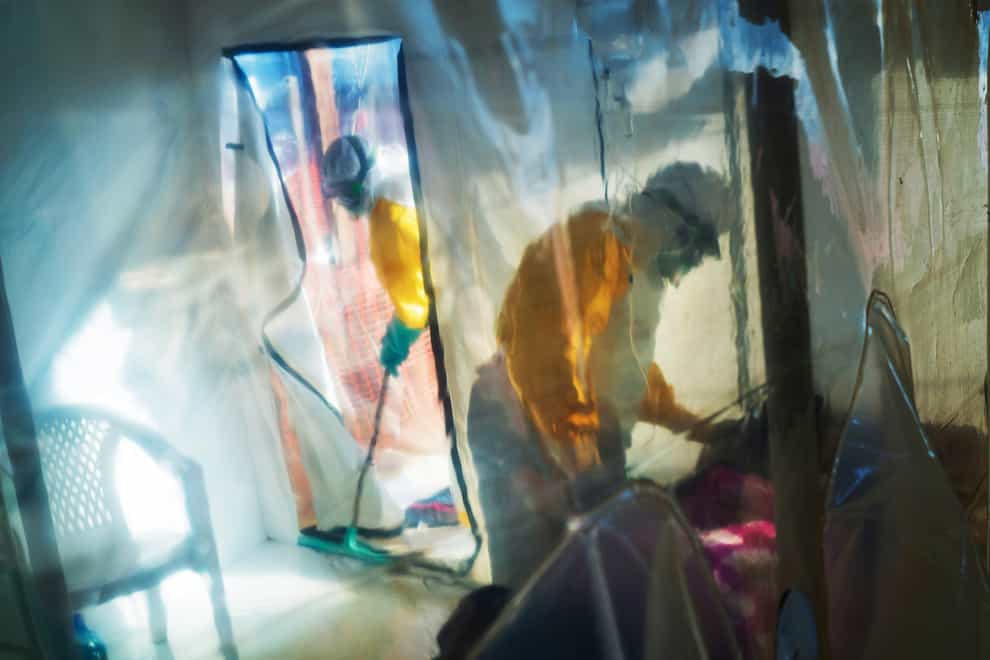 Health workers wearing protective suits tend to to an Ebola victim kept in an isolation tent in Beni, Democratic Republic of the Congo (AP)