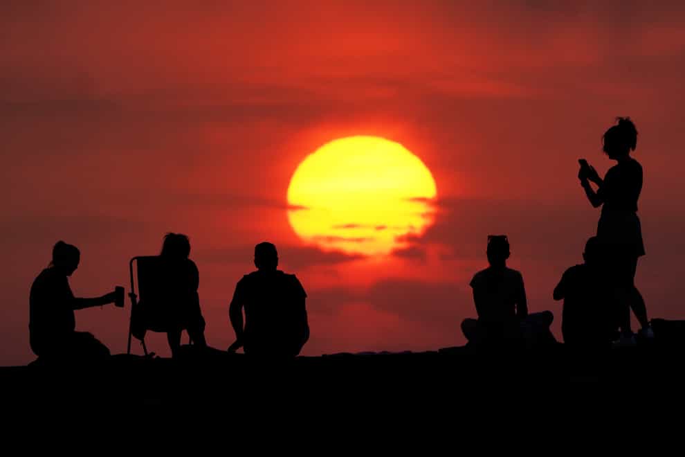 People turn out to watch the sunrise ahead of the hottest day on record (Owen Humphreys/PA)