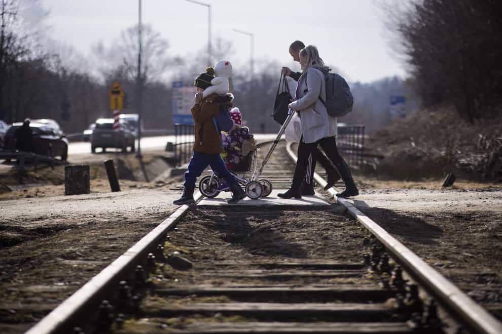Ukraine refugees cross over the railway tracks at the Krościenko border crossing point on the Poland/Ukraine border (Toby Madden/DEC/PA)