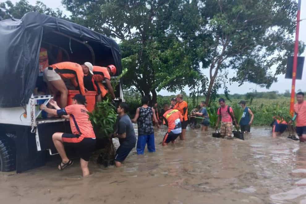 Rescuers help residents move to safer ground in Tuguegarao, Cagayan province, northern Philippines (Philippine Coast Guard/AP)