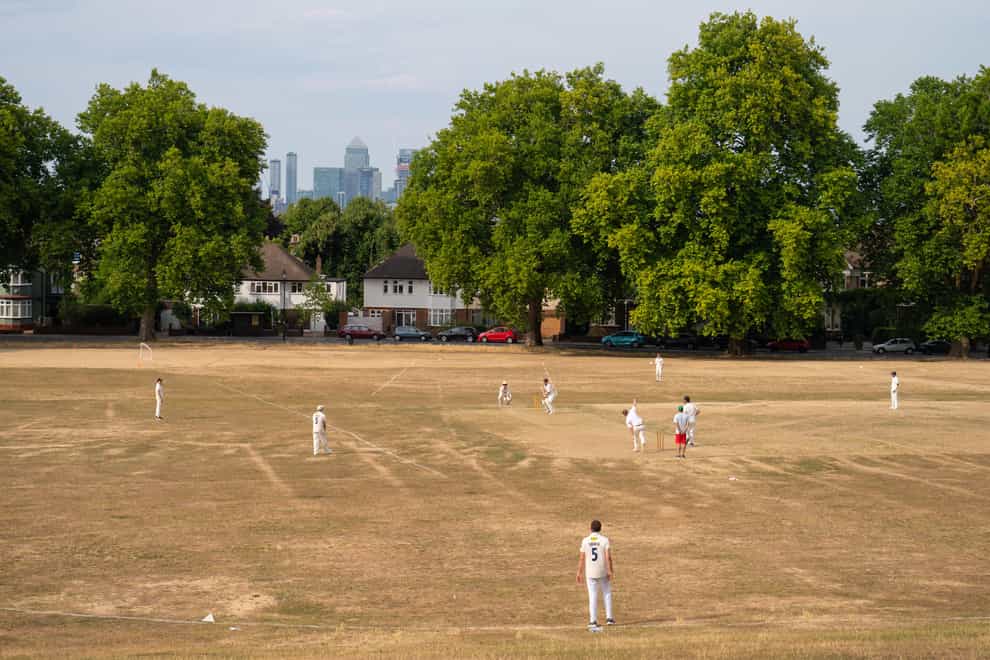 Cricketers play on a parched pitch in south east London in August (Dominic Lipinski/PA)