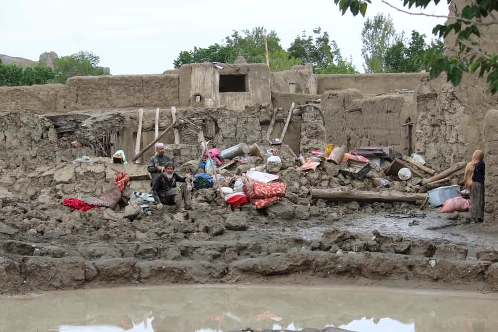People collect their belongings from their damaged homes after heavy flooding in the Khushi district of Logar province south of Kabul, Afghanistan (Shafiullah Zwak/AP/PA)