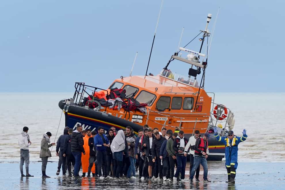 A group of people thought to be migrants walk ashore in Dungeness, Kent, after being intercepted by the Dungeness Lifeboat following a small boat incident in the Channel (Gareth Fuller/PA)