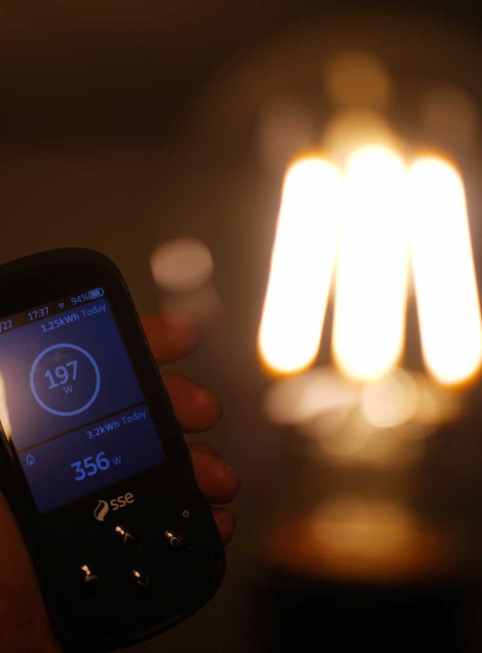 A handheld SSE smart meter for household energy usage is held next to an energy-efficient LED light bulb. The Government has been urged to act to tackle rising energy bills (Yui Mok/PA)