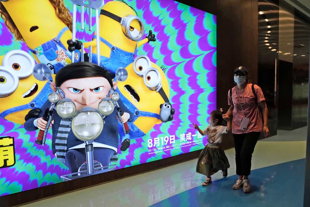 Visitors to a cinema showing Minions: The Rise Of Gru pass an advertisement for the film in Beijing (Ng Han Guan/AP)