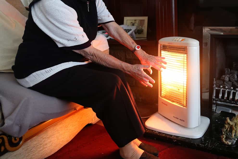 An elderly lady with her electric fire on at home (PA)