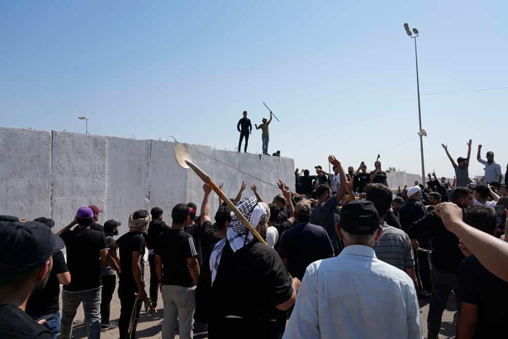 Supporters of Shiite cleric Muqtada al-Sadr try to remove concrete barriers in the Green Zone area of Baghdad, Iraq (Hadi Mizban/AP)