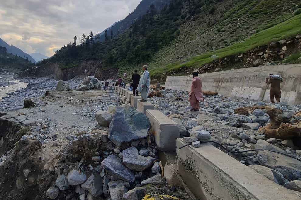 Residents examine a portion of road destroyed by floodwaters in the Kalam Valley in northern Pakistan (Sherin Zada/AP)