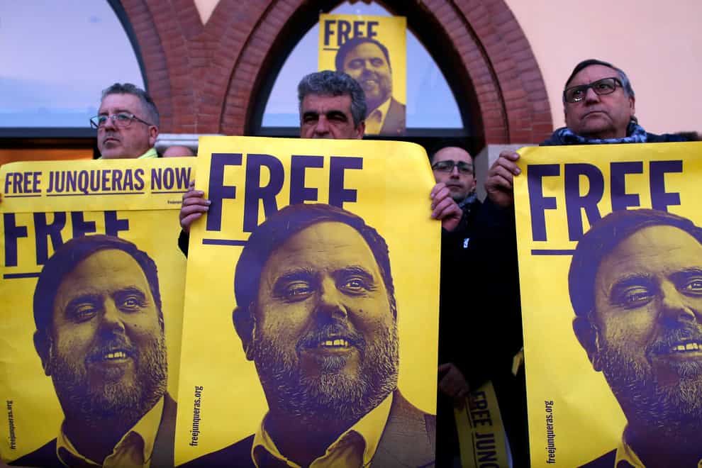 Demonstrators hold banners with an image of former Catalan vice president Oriol Junqueras on them (Manu Fernandez/AP)
