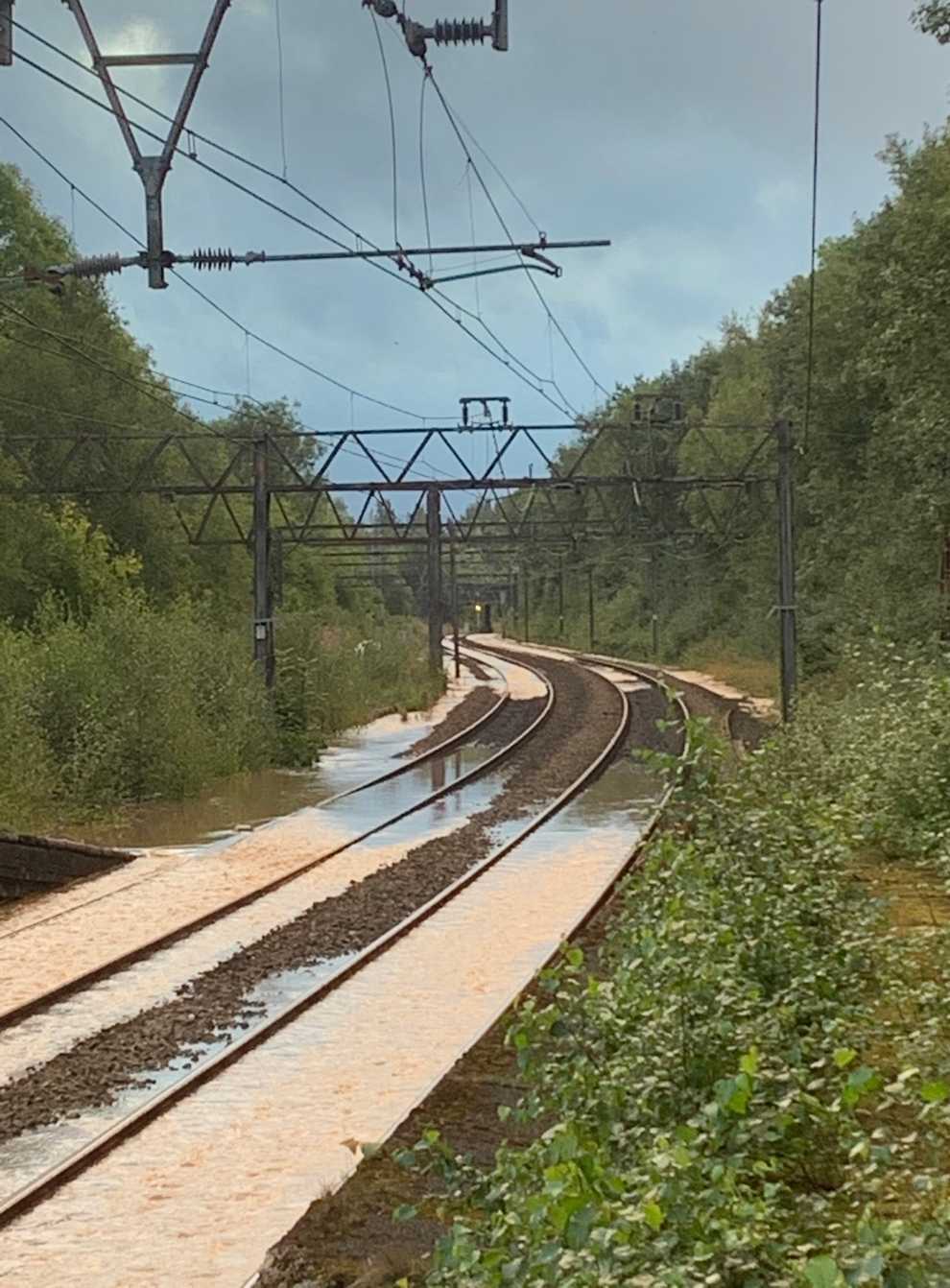 Train services in parts of northern England are severely disrupted after a burst water main flooded tracks (Network Rail/PA)