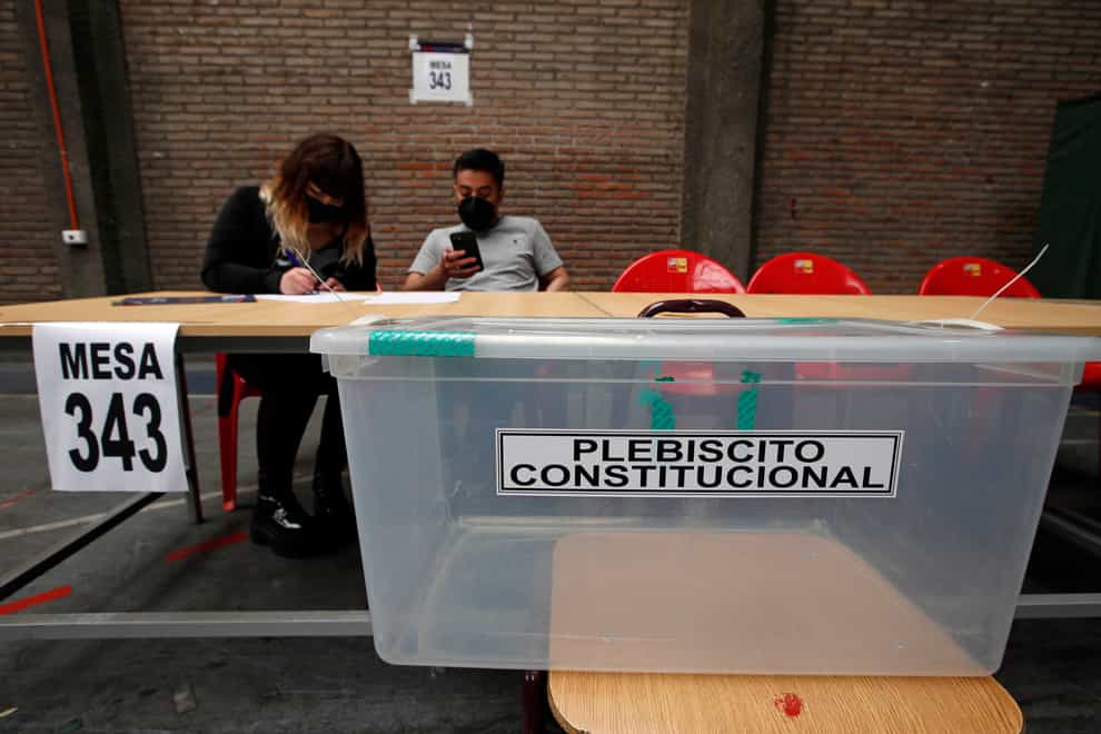 Poll workers prepare for a referendum vote on the draft of a new constitution at a polling station in Santiago, Chile (Luis Hidalgo/AP)