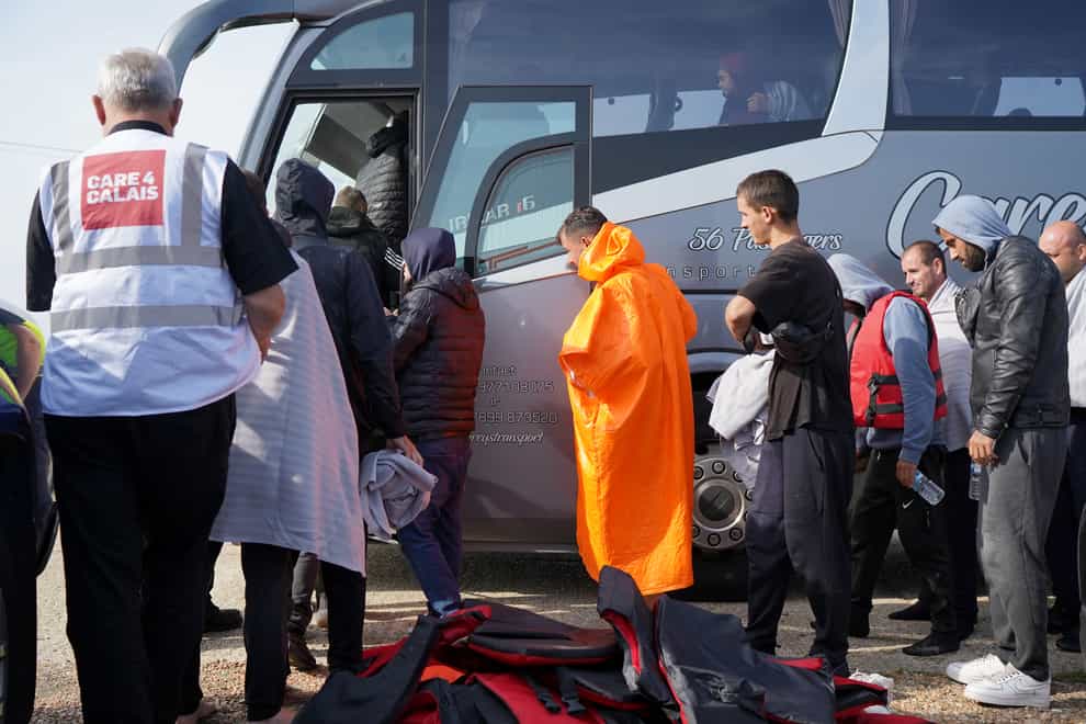 A group of people thought to be migrants are escorted on to a bus in Dungeness, Kent, after being intercepted by the Dungeness Lifeboat (Gareth Fuller/PA)