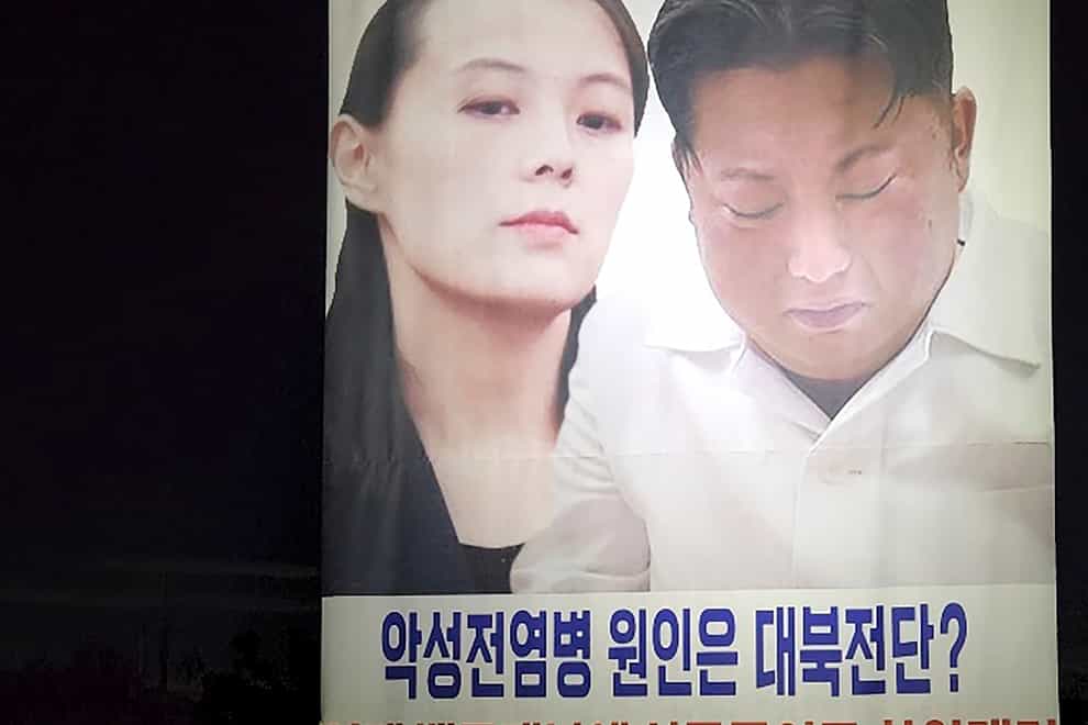 Park Sang-hak holds a placard carrying pictures of North Korean leader Kim Jong Un and his sister Kim Yo Jong in Ganghwa, South Korea (Fighters for a Free North Korea via AP)