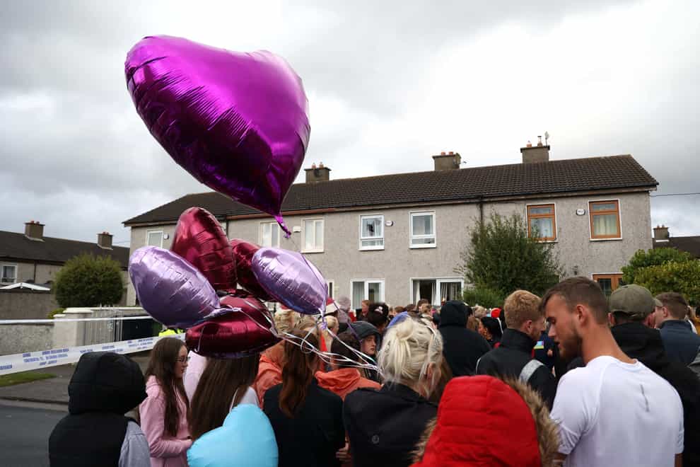 People attend a vigil outside a house on Rossfield Avenue in Tallaght, Dublin, where Lisa Cash, 18, and her eight-year-old twin siblings Christy and Chelsea Cawley died in a violent incident. Picture date: Monday September 5, 2022.
