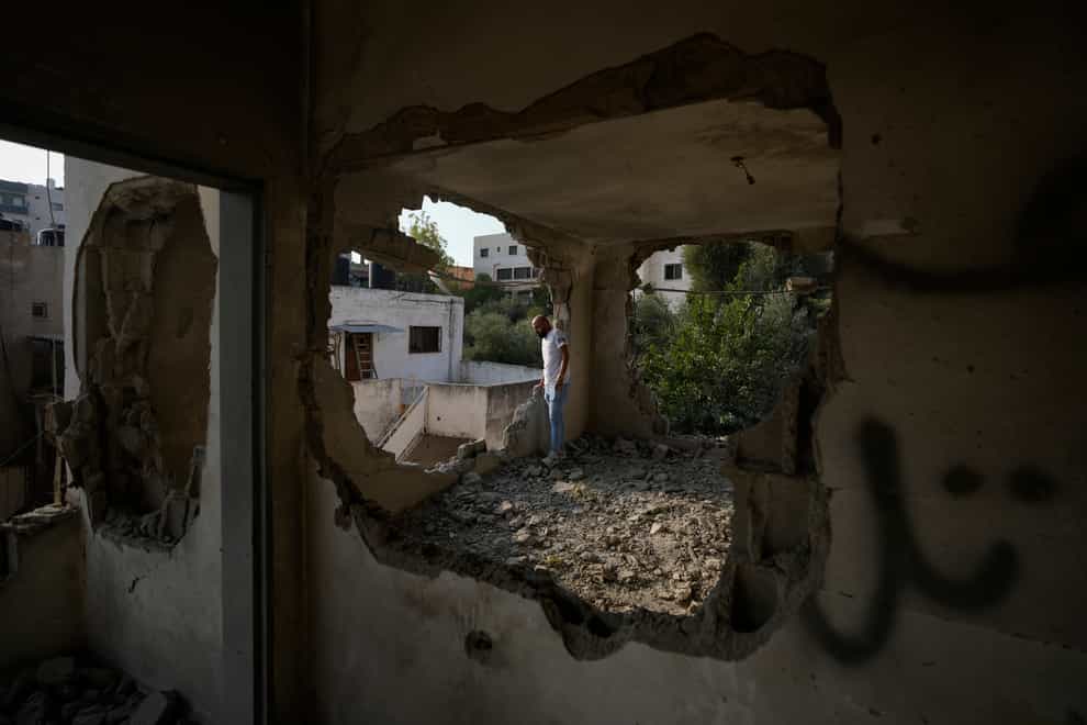People look at the demolished house of Palestinian gunman Raed Hazem, who carried out a deadly attack in Tel Aviv in April, after it was destroyed by Israeli forces in the West Bank city of Jenin (Majdi Mohammed/AP)