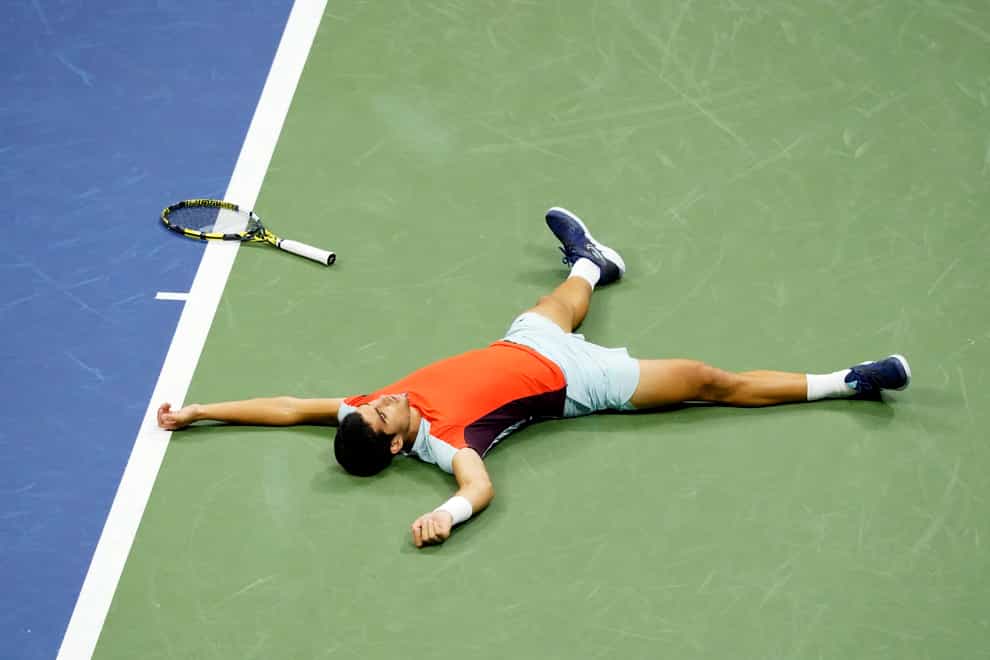 Carlos Alcaraz lies on the court after beating Frances Tiafoe (Mary Altaffer/AP)