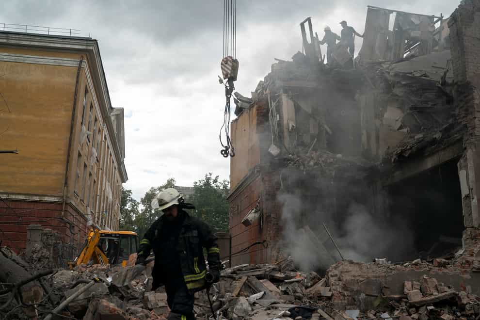 Firefighters work to extinguish a fire as they look for potential victims after a Russian attack that heavily damaged a residential building in Sloviansk, Ukraine (Leo Correa/AP)