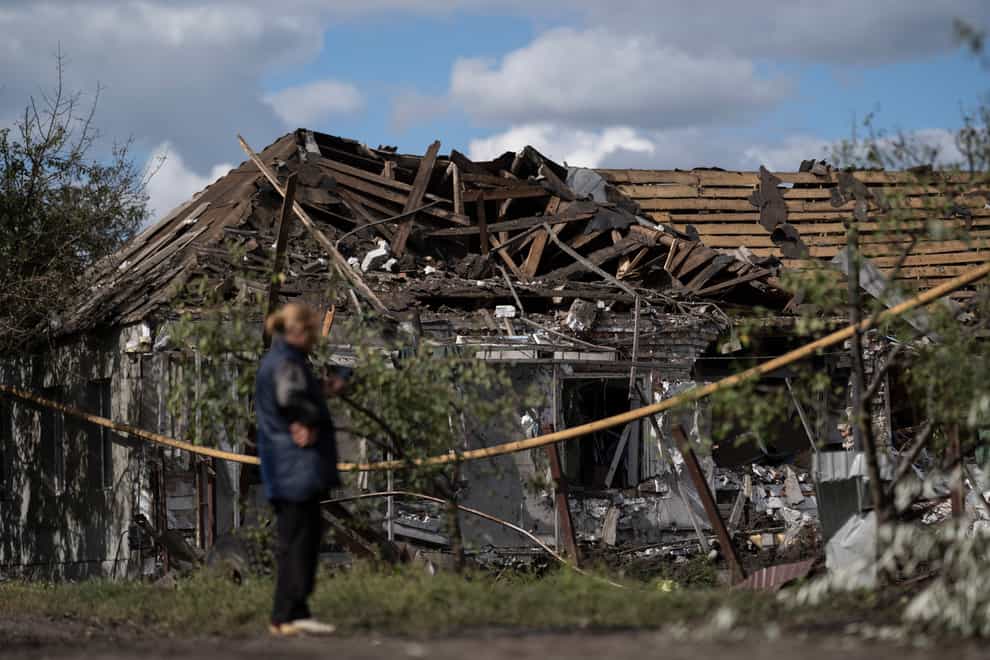 A woman stands in front of a house that was heavily damaged after a Russian attack in Sloviansk, Ukraine (AP)