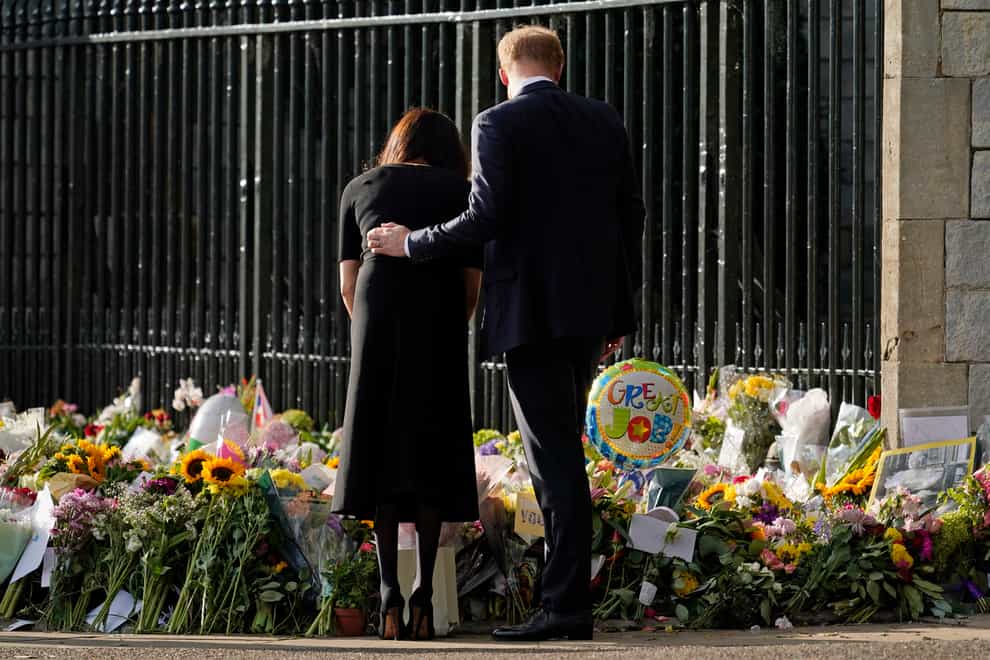 Harry and Meghan view the floral tributes for the Queen outside Windsor Castle (AP)