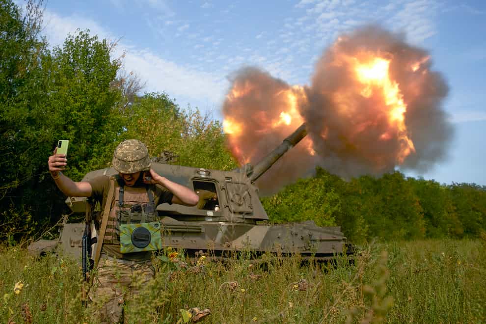 A Ukrainian soldier takes a selfie as an artillery system fires on the front line in Donetsk region, eastern Ukraine (Kostiantyn Liberov/AP)
