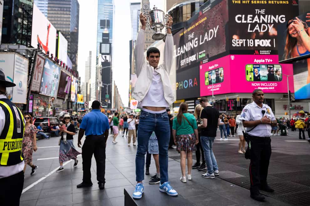 Carlos Alcaraz held up the US Open trophy in Times Square (Yuki Iwamura/AP)