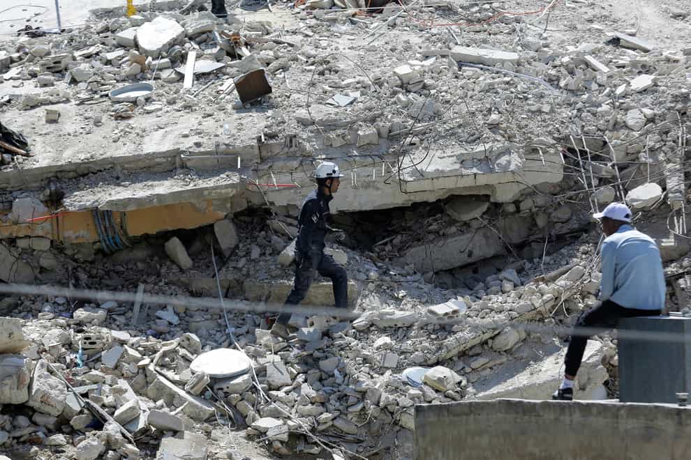 Jordanian Civil Defence rescue teams conduct a search operation for residents of a four-storey residential building that collapsed on Tuesday (Raad Adayleh/AP)