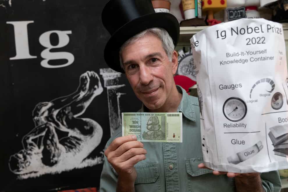 Master of Ceremonies Marc Abrahams poses with the 2022 Ig Nobel prize (Michael Dwyer/AP)