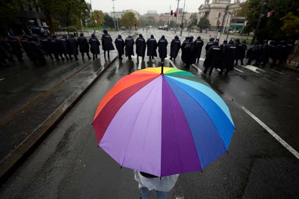 Riot policemen line up to prevent anti-gay protesters from clashing with marchers (Darko Vojinovic/AP)