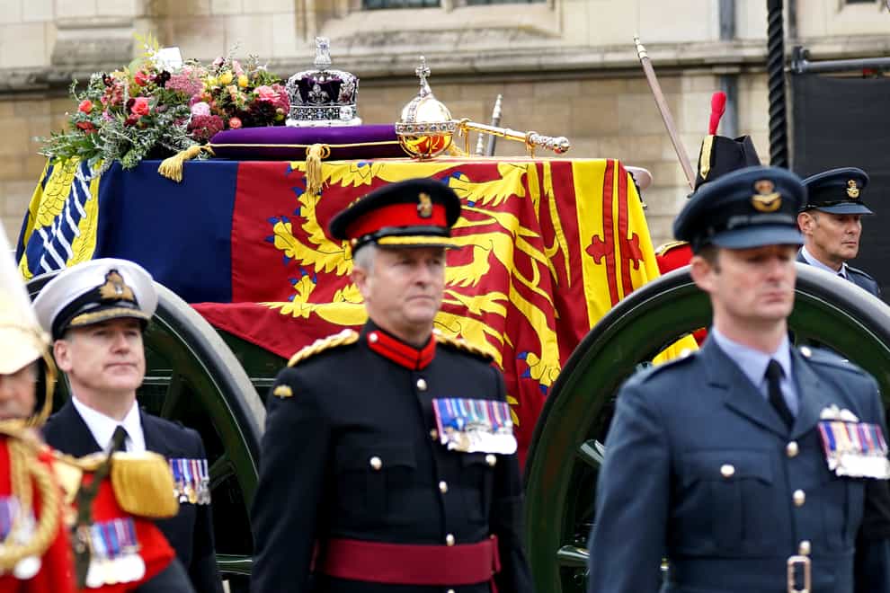 The State Gun Carriage carries the coffin of Queen Elizabeth II, draped in the Royal Standard with the Imperial State Crown and the Sovereign’s orb and sceptre, as it leaves Westminster Hall for the State Funeral at Westminster Abbey, London. Picture date: Monday September 19, 2022.