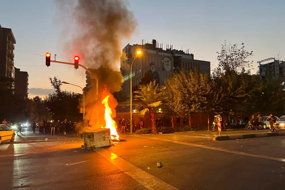 In this Monday, Sept. 19, 2022, photo taken by an individual not employed by the Associated Press and obtained by the AP outside Iran, a police motorcycle is burning during a protest of the death of a young woman who had been detained for violating the country’s conservative dress code, in downtown Tehran, Iran. (AP Photo)