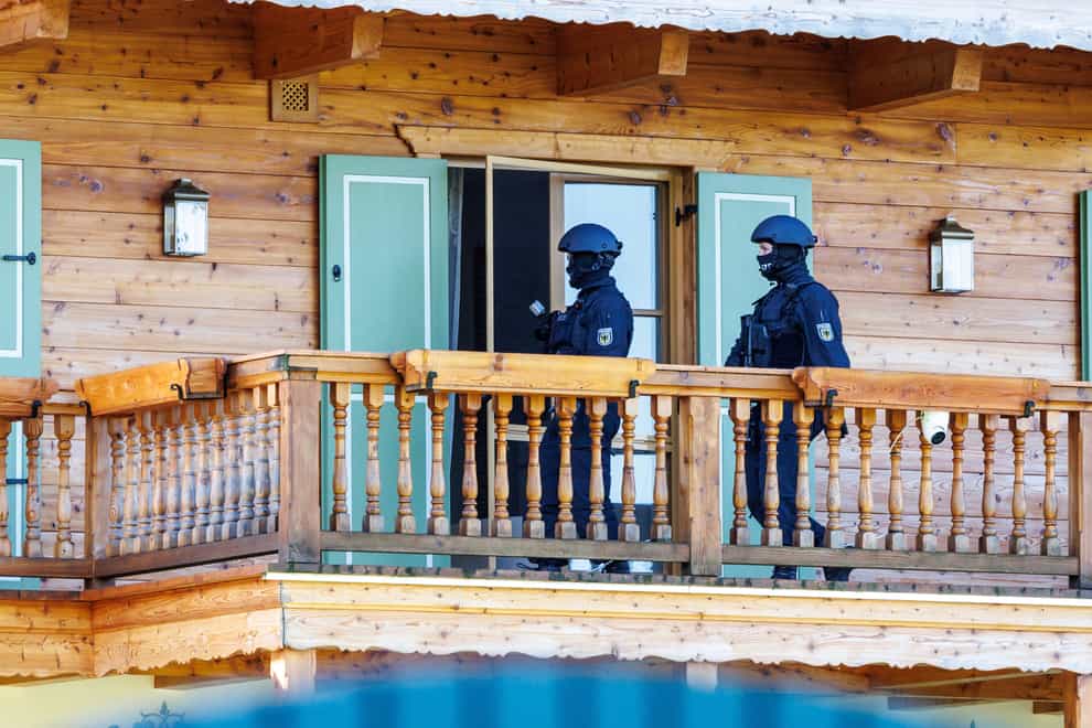 Masked police officers on the balcony of a house belonging to Russian oligarch Alisher Usmanov during a raid in Rottach-Egern in Germany (Matthias Balk/dpa via AP)