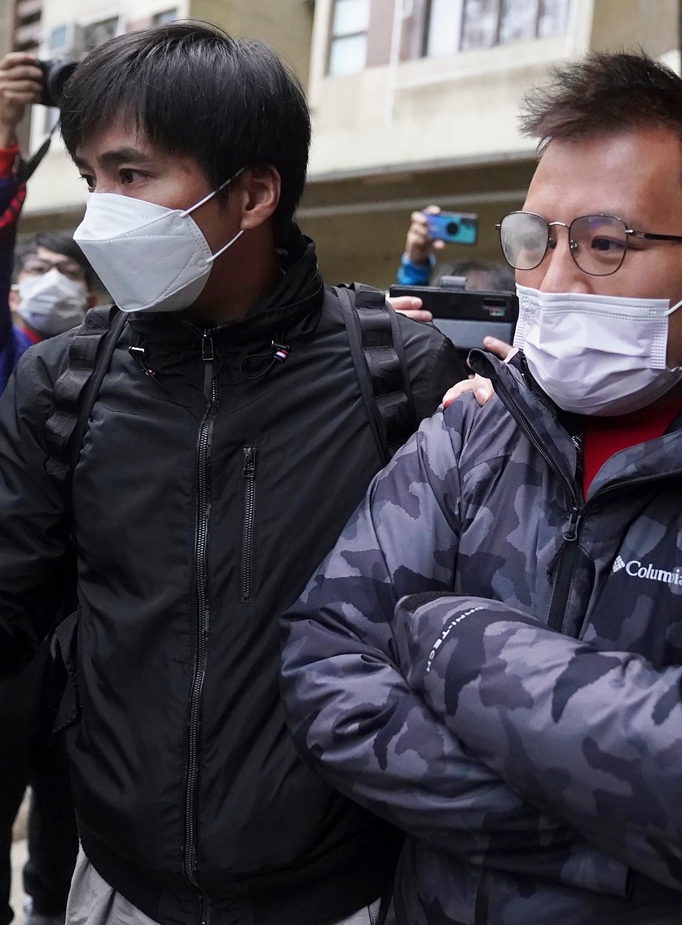 Senior editor of Stand News, Ronson Chan, centre, is arrested by police officers in Hong Kong (AP)