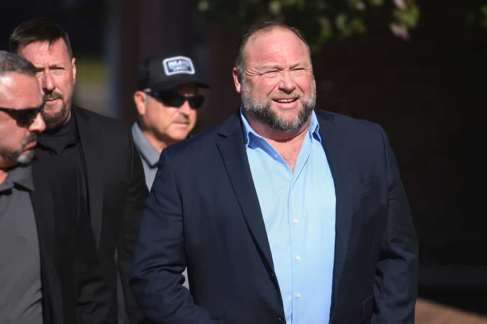 Alex Jones, right, enters court with members of his security team (Tyler Sizemore/Hearst Connecticut Media/AP)