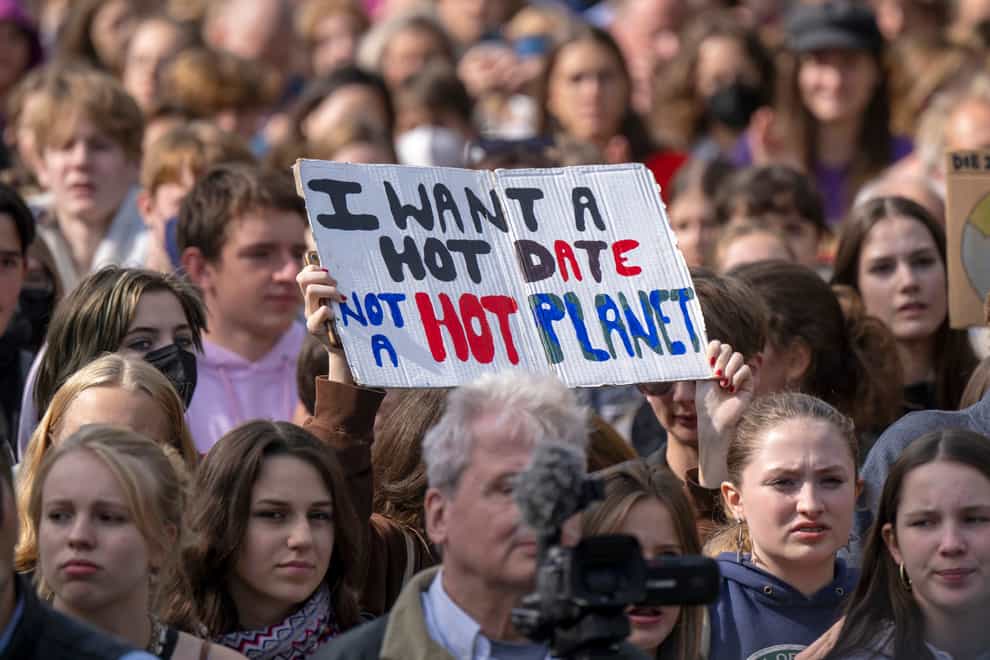 A sign reading ‘I want a hot date, not a hot planet’ is held up in the crowd during a demonstration in Berlin (Monika Skolimowska/dpa via AP)