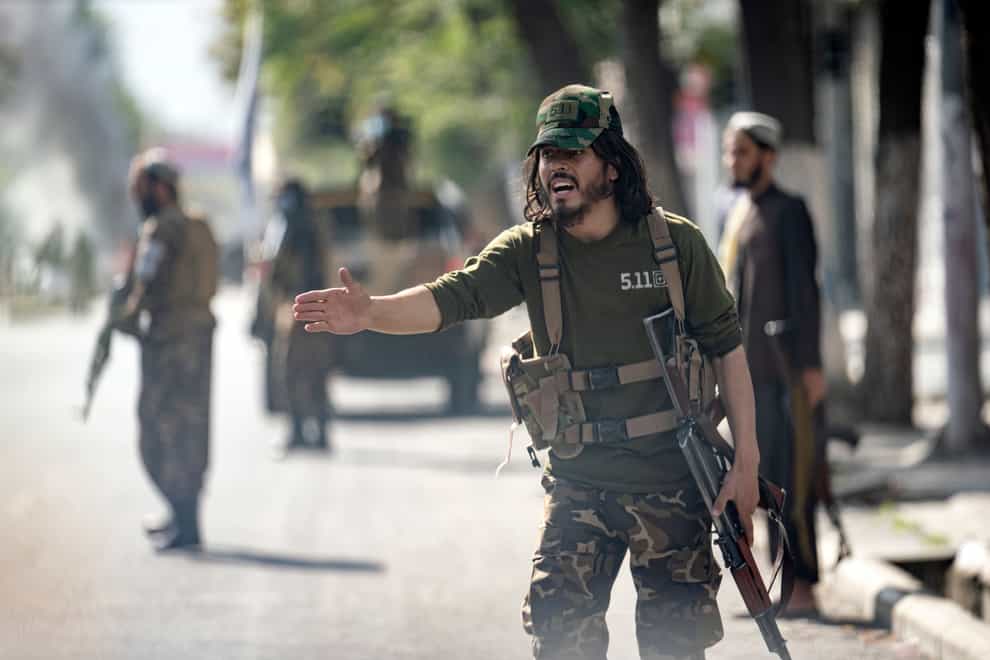 Taliban fighters stand guard at the explosion site, near a mosque, in Kabul (Ebrahim Noroozi/AP)
