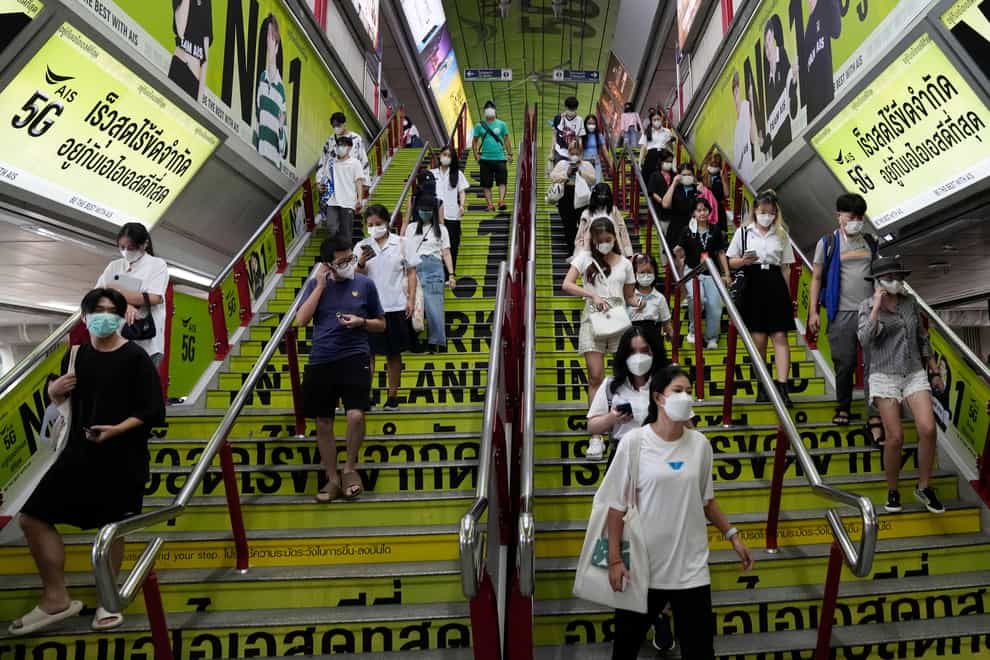 Commuters wearing face masks to help curb the spread of the coronavirus at a skytrain station in Bangkok (Sakchai Lalit/AP)