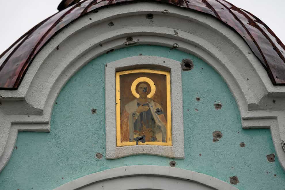 A religious icon is seen damaged from shrapnel at the entrance of a chapel in the retaken village of Bohorodychne, eastern Ukraine (Leo Correa/AP)