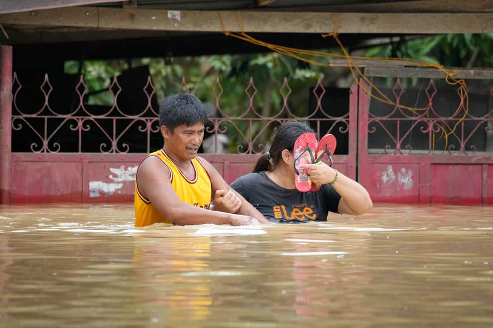 Residents negotiate a flooded road due to Typhoon Noru in San Miguel town, Bulacan province (AP)