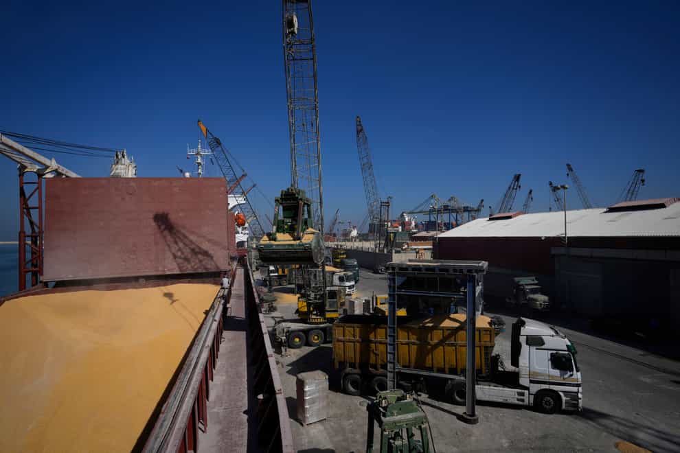 Trucks being filled with Ukrainian corn from the ship AK Ambition, sailing under the flag of Panama at Tripoli seaport (Hassan Ammar/AP)