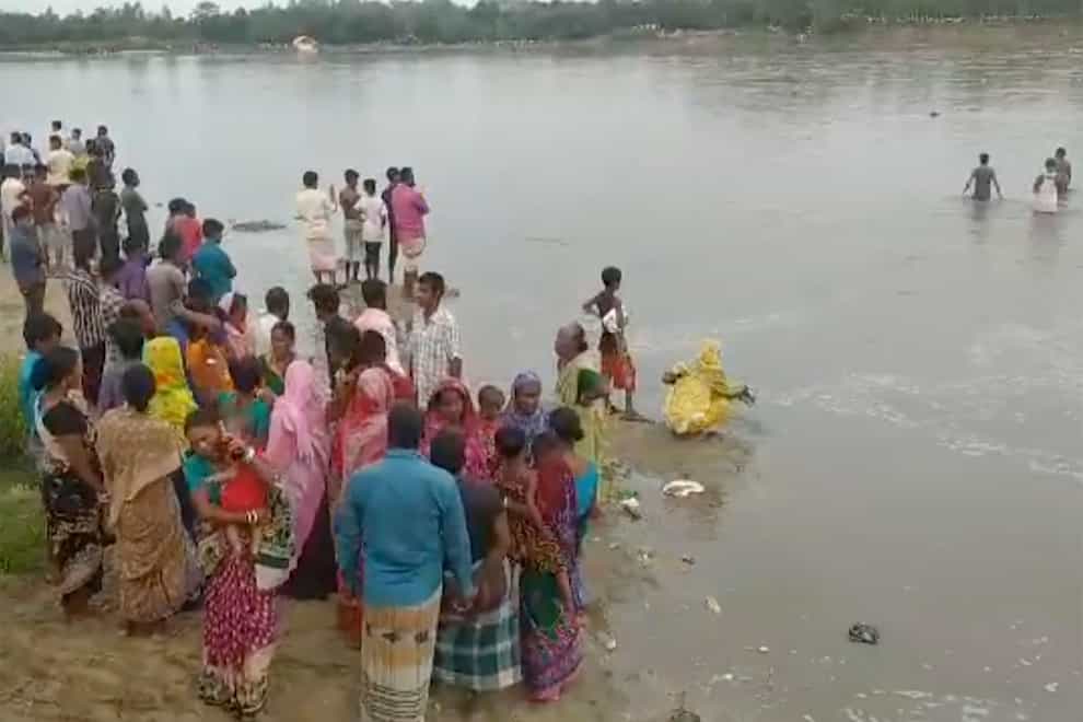 In this image made from a video, people conduct search operation in the River Karatoa where an overcrowded boat overturned, in Panchagarh, Bangladesh Sunday, Sept. 25, 2022. A boat carrying about 100 Hindu pilgrims capsized Sunday in the river in northern Bangladesh, police said. (AP Photo)