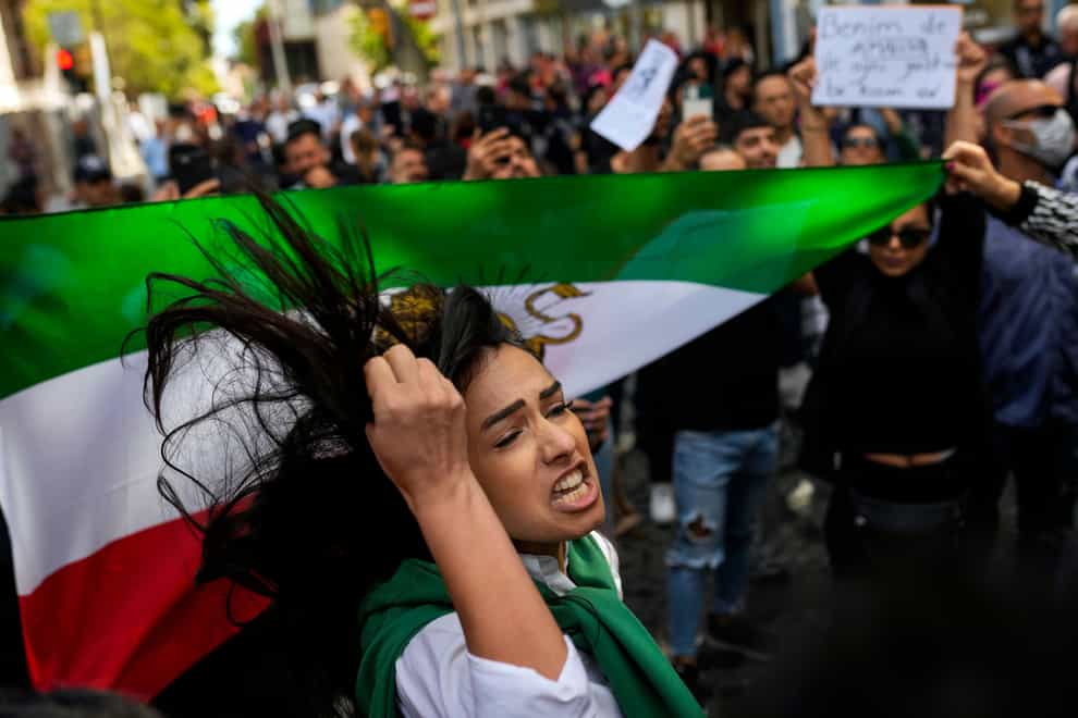 A woman shouts slogans next to an Iranian flag during a protest against the death of Iranian Mahsa Amini, outside Iran’s general consulate in Istanbul, Turkey, Wednesday, Sept. 21, 2022. Protests have erupted across Iran in recent days after Amini, a 22-year-old woman, died while being held by the morality police for violating the country’s strictly enforced Islamic dress code. (AP Photo/Francisco Seco)