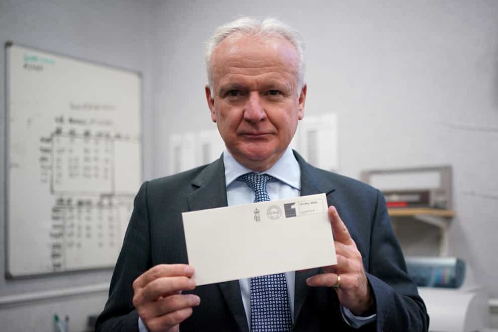 David White, Garter King of Arms, holding one of the first letters to be franked with the new cypher of King Charles III (/PA)