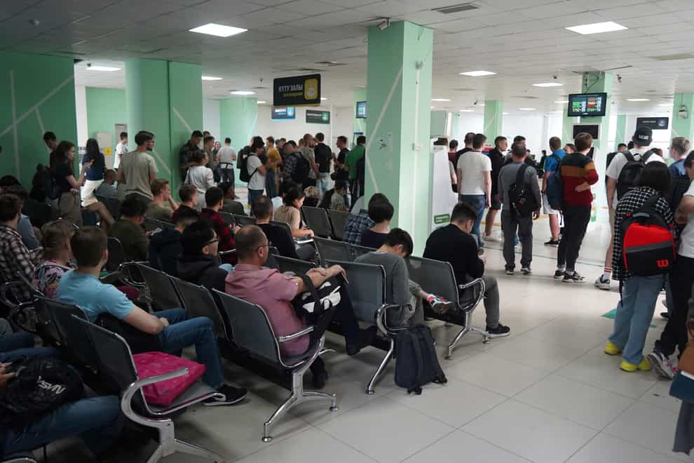 Russians wait and lineup to get Kazakhstan’s INN in a public service center in Almaty, Kazakhstan, Tuesday, Sept. 27, 2022. A day after President Vladimir Putin ordered a partial mobilization to bolster his troops in Ukraine, many Russians are leaving their homes. (Vladimir Tretyakov/NUR.KZ via AP)