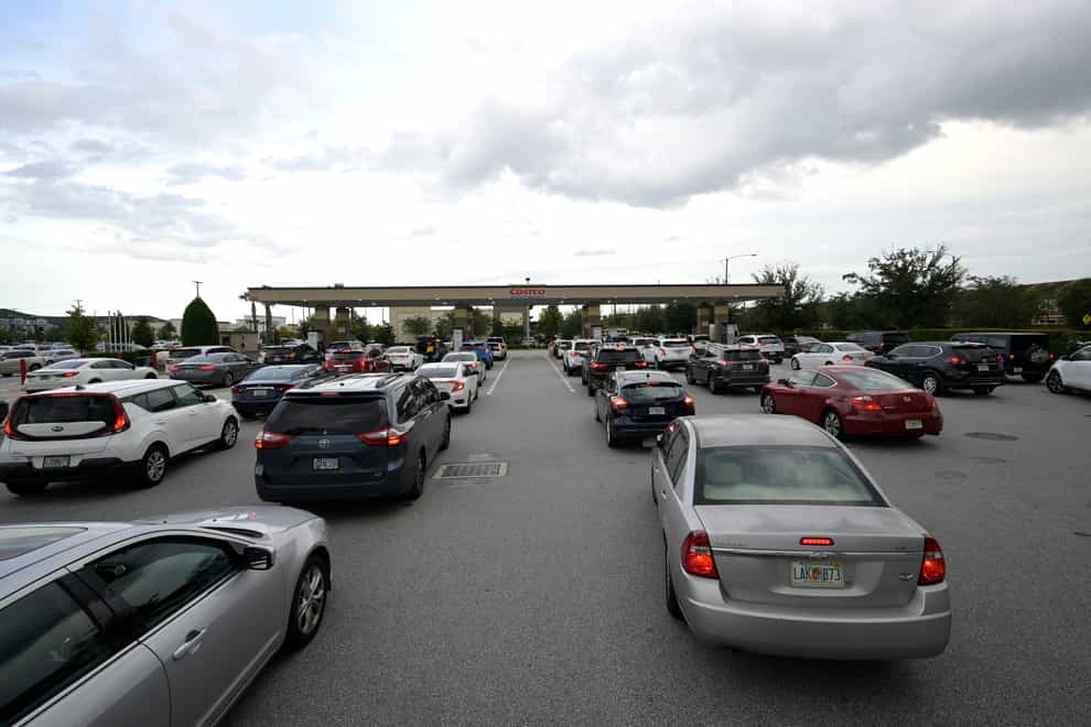People wait in lines to fuel their vehicles at a Costco Wholesale store in preparation for the arrival of Hurricane Ian, Monday, Sept. 26, 2022, in Orlando, Fla. Ian was growing stronger as it approached the western tip of Cuba on a track to hit the west coast of Florida as a major hurricane as early as Wednesday. (AP Photo/Phelan M. Ebenhack)